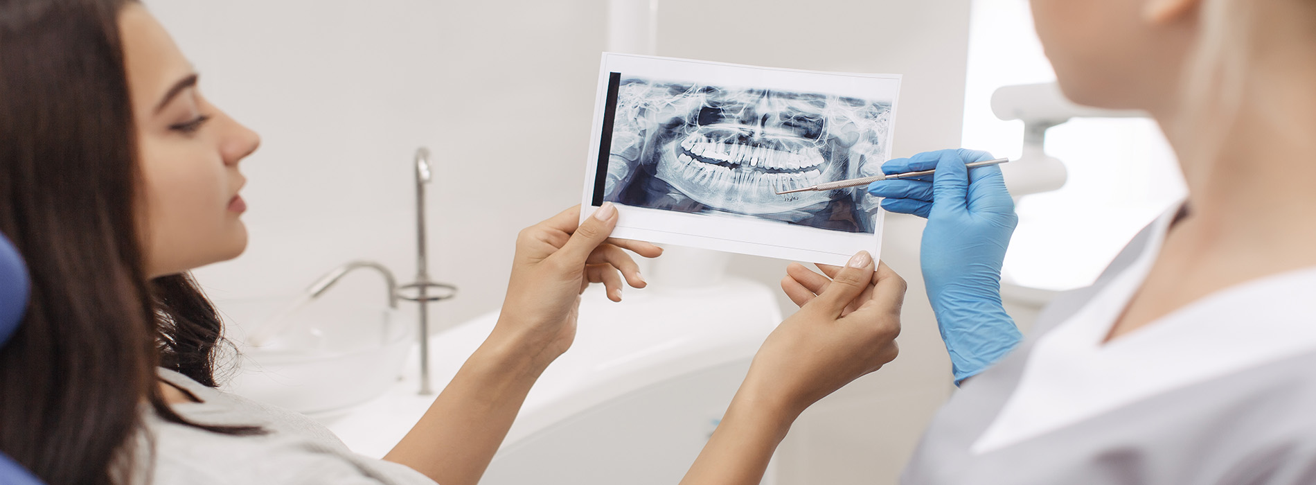 A dental professional showing a digital dental model to a patient, with a focus on oral health and dental technology.
