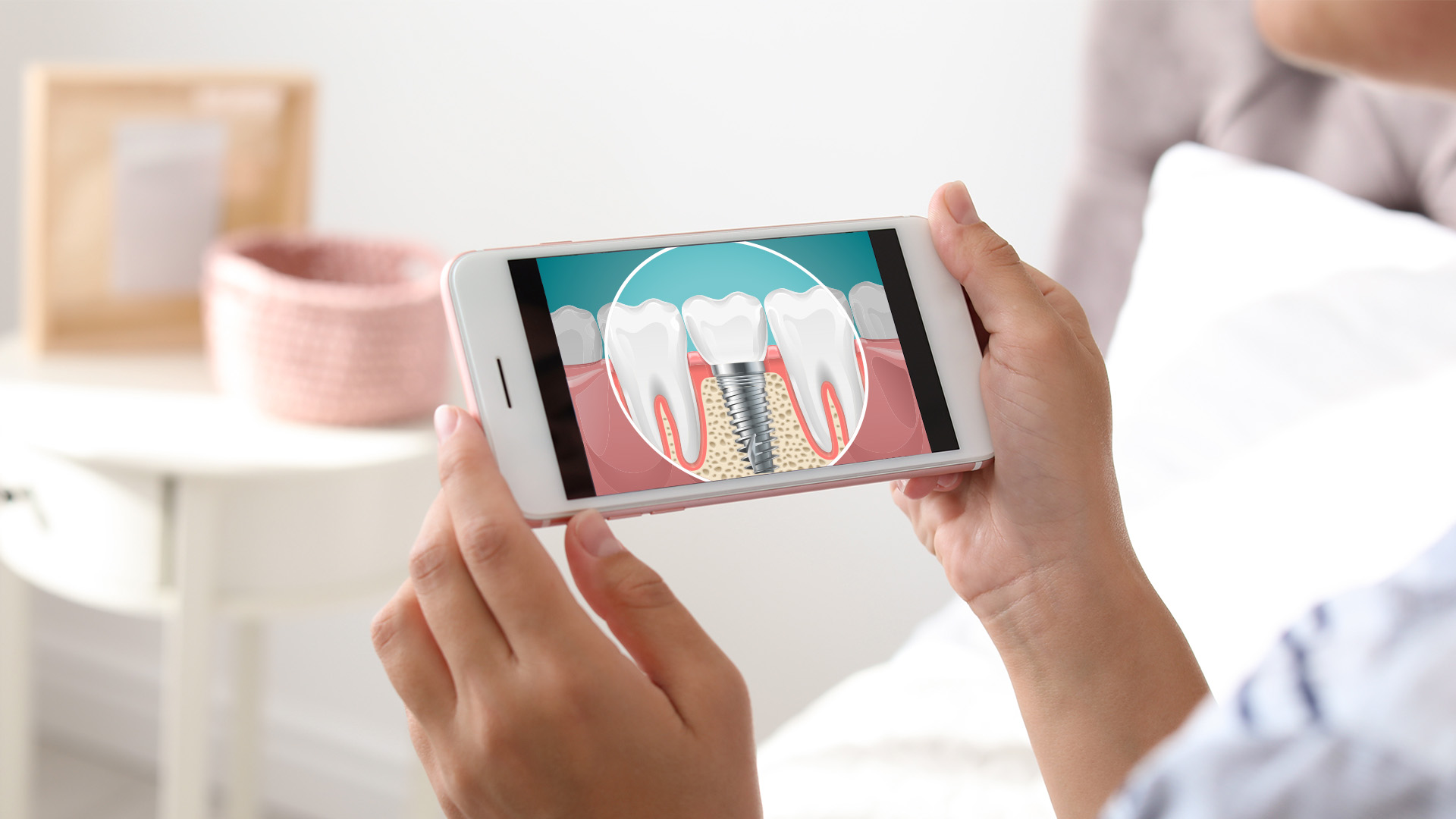 Person holding a smartphone displaying an image of a tooth with a cavity and gum disease, showcasing oral health care.