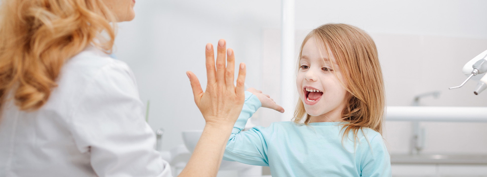 The image shows a woman and a young girl in a bathroom setting, with the woman appearing to interact with the child.